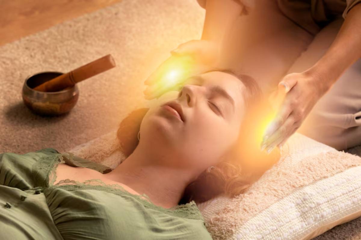 A person receives a relaxing energy healing treatment, surrounded by soft natural lighting and a serene environment with a singing bowl nearby.