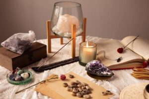A mystical flat lay featuring crystals, a candle, an open book, and numbered stones on lace, creating an enchanting ambiance.